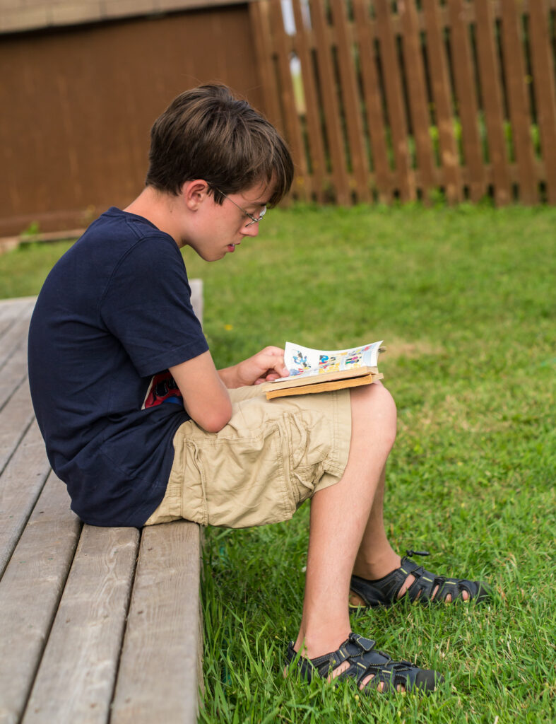 Boy reading the best comics for new comic readers.